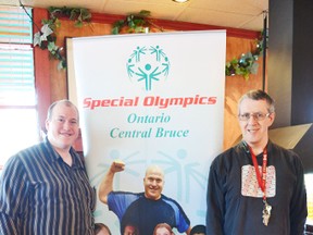 Pictured standing beside the Special Olympics Central Bruce poster is Jeremy Kranenburg, who happens to be represented on the poster and Murry Majury.