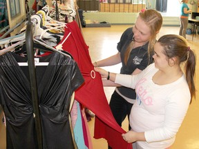 Students Martha Friesen, 18, left,  and Vanessa Haskell, 17, admire one of the $20 prom dresses for sale at the Ursuline College Chatham Dress Drive in Chatham, Ontario on Thursday, April 25, 2013.
(VICKI GOUGH/ THE CHATHAM DAILY NEWS/ QMI AGENCY)