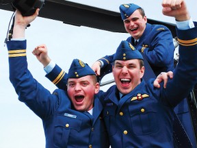 Lt. Shane Lichty (back), Cpt. Robert Hannam (left) and Lt. Jerome Trudel cheer on their graduation day at 3 Canadian Forces Flying Training School at Southport on April 26. Lichty won the Goss Goulding Trophy for Rotary Wing Flying Excellence and the City of Portage la Prairie Flying Award. (Svjetlana Mlinarevic/The Graphic/QMI Agency)