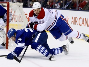 Leafs defenceman John-Michael Liles is taken down by the Canadiens' Travis Moen on Saturday night at the Air Canada Centre. (Dave Abel/Toronto Sun)