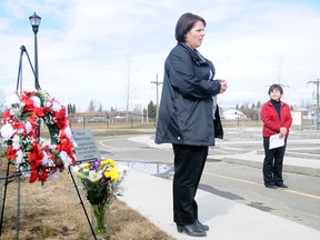 Kim Webber, left, speaks to a small crowd, as Donna Kulba, director for Grande Prairie and Area Safe Communities watches during Grande Prairie's ceremony for the National Day of Mourning Sunday, April 28, 2013 at Safety City. The event honours those injured or killed in workplace accidents. Webber's father was killed in a workplace accident in 2007. ADAM JACKSON/HERALD-TRIBUNE STAFF/QMI AGENCY