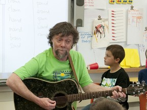 David Archibald plays his guitar while students suggest lyrics for a song about Earth Day.