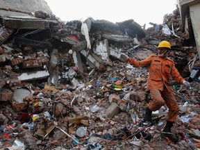 A rescue worker attempts to find survivors from the rubble of the collapsed Rana Plaza building in Savar, Bangladesh. (Reuters)