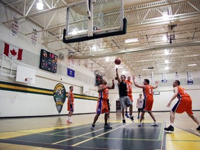 Chris Manahan of the Canmore Peaks goes for the layup surrounded by Calgary Fighting Tacos, from left, Steve King, John Cleland, Brent Allison, Mark Loria and Steve Beaumont during first-round action in the Peaks Tourney competitive over-35 division on Saturday. In the background is Peaks guard Shep Howatt, — not even remotely close to 35 — but added to the team to bolster the local roster. Russ Ullyot/ Canmore Leader