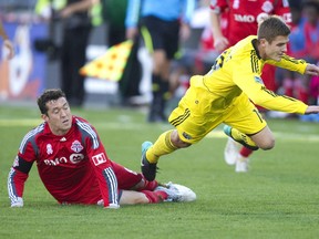 Former TFC defender Dan Gargan (L) tackles former Columbus Crew midfielder Robbie Rogers during the first half of their MLS soccer match in Toronto, October 16, 2010. (REUTERS)