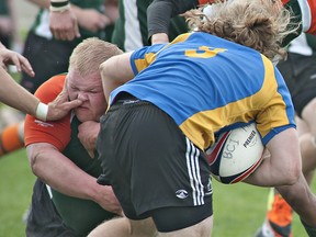 North Park Trojans defender John Evans gets more than he bargained for as he attempts to tackle a BCI Mustangs ball carrier during a senior boys high school rugby game on Tuesday at Tollgate Tech field in Brantford. (BRIAN THOMPSON Brantford Expositor)