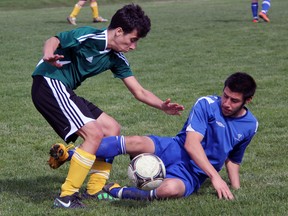 Jared Bagley, left, of the St. Pat's Fighting Irish jousts for a ball with Danielo Bucci of the St. Chris Cyclones in LSSAA senior boys soccer action Tuesday, April 30, 2013 at St. Chris in Sarnia, Ont. (PAUL OWEN, The Observer)