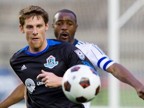 FC Edmonton's Daryl Fordyce, in black, battles a Vancouver Whitecaps player during the April 24 Game 1 match between the two teams. (Amber Bracken, Edmonton Sun)