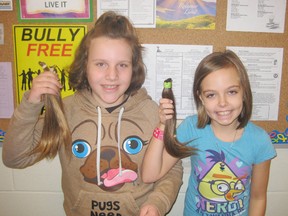 St. Frances Cabrini school Grade 4 students Erica Brock (left) and Hannah Kochany cut their hair recently to donate it to Pantene to be used in wigs for cancer patients. (Contributed photo)