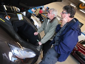 Dale Smith, left, and Bill Schepanovich scratch their heads trying to locate the engine in the Tesla Model S85 Roadster during the Future of Transportation Symposium and Car Show at the NAIT main campus last weekend. TREVOR ROBB EDMONTON EXAMINER