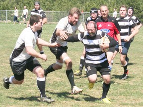 The Bruce County RFC Barbarians, decked out in their black and white striped shirts, are gearing up for another busy season, and took to the field in Tiverton for a friendly match against the Sarnia Saints club on Saturday, April 27, 2013. Barbarian Ryan Clancy fends off defenders during the match. (JOHN F. ADAMS/KINCARDINE NEWS FREELANCE)