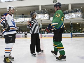 Referee, and Speaker of the Alberta Legislature, Gene Zwozdesky speaks with MLA Steve Young (right) and Oilers alumni Rob Brown before the opening face off of the Pro-Am Face Off for Alzheimer’s Exhibition Hockey Game at the Ice Palace at West Edmonton Mall last week.