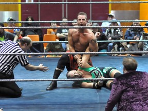 Former WWE superstar Robbie MacAllister, founder of Canadian Professional Wrestling, puts Jake O'Reilly in an arm hold, while former WWE referee Korderas looks on during Gold Rush 2013 in Timmins on April 14, 2013. CPW will bring "Punishment in Paris" to town on May 10 at the Paris Fairgrounds. CHRIS RIBAU/QMI AGENCY