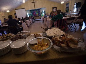 Canmore residents partake in a meal at St. Michael’s Anglican church on Monday. Community food and friends nights being held  each Monday night at the church have been gaining popularity among individuals and families who have difficulties affording food as well as those seeking a hearty meal and good conversation. Justin Parsons/ Canmore Leader