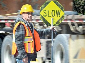 Flagman Eugene Weir keeps traffic moving safely during the start of construction that will lead to the creation of a roundabout on Highway 7 at Wildwood Conservation Area Wednesday. (SCOTT WISHART The Beacon Herald)