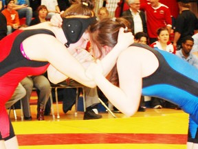 Amber Fergusson (left) gets into position on the mats against her opponent.