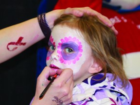 Melissa Armstrong, 4, gets her face painted at Grace Family Dental's booth.