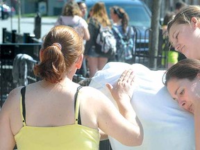 Karma Restaurant and Pizzeria owner Mike Saunders is comforted by, from left, Tammy Raycraft, wife and restaurant co-owner Sherry Saunders and Payton Huff following a fire in the business Thursday afternoon in downtown Stratford. (SCOTT WISHART, The Beacon Herald)