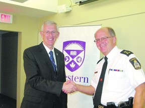 Former OPP deputy commissioner John Carson, left, is congratulated by London Police Chief Brad Duncan as Carson takes the helm of campus police for Western University Thursday. Carson has served two years as operations leader for the campus police after his OPP career, which included a position as deputy commissioner.