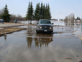 A truck drives through the parking lot at the Mattagami River boat launch in Timmins on Thursday. Roads were closed throughout the city as waters continue to rise in the Mattatagmi River. City officials fear the river could rise another 12-18 inches by Friday and even more through the weekend.