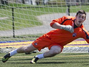 Kingston FC goalkeeper Andrew Murphy dives to make a save during a team workout at Queen’s University’s west campus on Thursday. (Julia McKay/For The Whig-Standard)