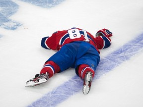 Canadiens forward Lars Eller lies on the ice after receiving a hit from Senators forward Eric Gryba. (Ben Pelosse/QMI Agency)