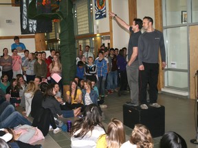 Jeff Richards points to a bidder while fellow item-member Clint Fenelon poses for Sell-a-Saint. St. Thomas Aquinas high school auctioned off five teachers and numerous students on Thursday for Survivor Week. The teachers or students became the servants of the highest bidders with all of the money raised going towards the Canadian Cancer Society. 
GRACE PROTOPAPAS/Daily Miner and News