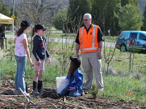 Glen Morris Public School Grade 4 students Zara Keefe, left, Brooke Martin and Jenna Vey get some advice on tree planting from Kevin Mitchell of Dufferin Aggregates. The girls were just a few of the students helping Dufferin plant 200 trees on a part of the site owned by Dufferin which the company won't excavate over the years as part of its Paris sand and gravel pit. Dufferin plans to mine the area north and south of Watts Pond Road making up more than 600 acres. MICHAEL PEELING/The Paris Star/QMI Agency
