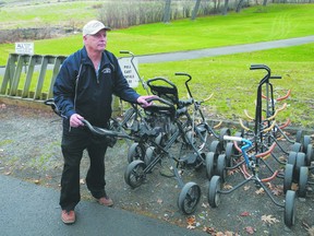 Bob Dunn, manager at Gananoque Golf Club, adjusts the golf carriers on a drizzy day Monday. While it has been a slow start to the season, due to the weather, local courses have made it through the winter in good shape.
Wayne Lowrie/Gananoque Reporter