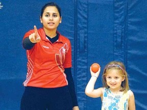 Canadian national cricket team member Monali Patel gives a few pointers on bowling to Neve Moir at Avon Public School Friday. (SCOTT WISHART, The Beacon Herald)