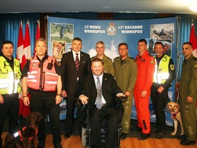 Search and rescue dogs Flash (front left) and Kegji (second from right) join MPs Stephen Fletcher (center) and James Bezan (third from left) along with search & rescue personnel from the Royal Canadian Air Force, the Office of the Fire Commissioner, and Search & Rescue Manitoba at the announcement at 17 Wing in Winnipeg. (Glen Hallick, Stonewall Argus & Teulon Times, QMI Agency)
