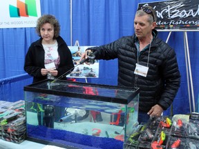 Svartzonker Canada Lures  give a demonstration of their products at the Kenora Home and Leisure show with an ice fishing rod and an aquarium.