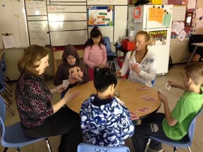 Out-of-School Care Coordinator Janet Huffman playing spoons with students in the program.
