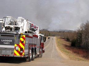 A reinforcement fire truck speeds down Resources Road as smoke rises from a 20-hectare forest fire in Weyerhaeuser on Saturday May 4, 2013.The fire started at roughly 3:30 p.m. near the mill and was heading northeast away from the area by about 6 p.m. County of Grande Prairie fire crews, the Weyerhaeuser Fire Department and Environment and Sustainable Resource Development still collaborating to bring the blaze under control, while tankers and helicopters dump water from above. ELIZABETH MCSHEFFREY/DAILY HERALD-TRIBUNE/QMI AGENCY