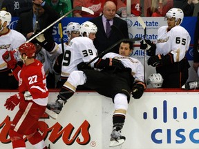 Anaheim Ducks defenceman Luca Sbisa is checked into the bench by Detroit Red Wings defenceman Kyle Quincey during Game 3 of their NHL playoff game in Detroit, May 4, 2013. (REUTERS/Rebecca Cook)