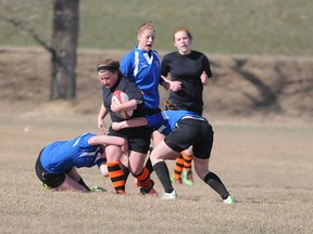 TERRY FARRELL/DAILY HERALD-TRIBUNE
Two Peace Wapiti Academy Titans converge to tackle Bailey Weibe of the Grande Prairie Composite Totems during the opening game of the local girls’ rugby high school on Thursday.  The league is comprised of four teams – three from Grande Prairie and one from Dawson Creek.