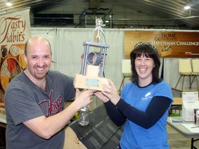 Laura Moore from Image One Designs awards Robert Kitowski his trophy for winning the first Handyman Challenge at the Kenora Home and Leisure show on May 5.