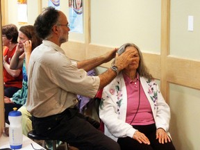 Mark Simkin performining subtle energy therapy with a patient at the Mind Body Spirit Fair in Kenora on May 5.