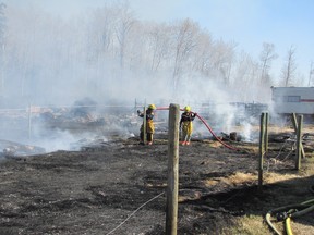 Two Mayerthorpe firefighters douse hot spots near the fire's origin.