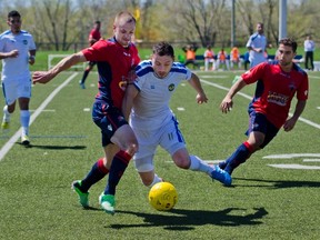 Brampton City United' Andrew DaSilva tries to get around Kingston FC George Anthony El-Asmer during the Kingston FC home game at Queen's Campus West on Sunday. Kingston won 6-2. (JULIA MCKAY For The Whig-Standard)