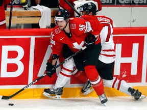 Switzerland's Julian Walker, left, fights for the puck with Canada's T.J. Brodie of Chatham during a preliminary-round game at the world hockey championship Sunday in Stockholm. (ARND WIEGMANN/Reuters)