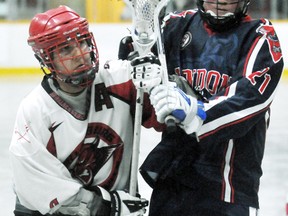 Wallaceburg Red Devils' Jordan Durston, left, fights for position with London Blue Devils' Chris Wilman in the second period Sunday at Wallaceburg Memorial Arena. (MARK MALONE/The Daily News)