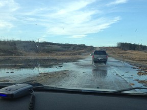 Motorists drive through flooded portions of Highway 63 on Sunday afternoon. Spring thawing flooded portion of the roads with water and mud. Marie-Claude Roy / Supplied Photo