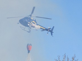 The Sustainable Resource Development helicopter drops water on the two-hectare fire.