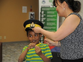 Elizabeth McSheffrey/Daily Herald-Tribune
Crime Prevention program manager Angela Sutherland helps six-year-old Tyler Sutherland try on an RCMP cap during the ‘Simple Connections... Stronger Kids,’ launch at City on 99th (10202-99 Street) on Monday.