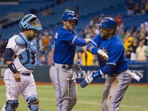 Blue Jays catcher J.P. Arencibia (centre) celebrates a home run against the Rays with teammate Emilio Bonifacio during at Tropicana Field in St. Petersburg, Fla., May 6, 2013. (SCOTT AUDETTE/Reuters)