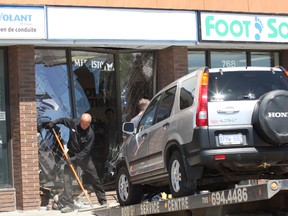 A vehicle is removed from a business after it crashed into a section of the Montrose Mall on Tuesday. JOHN LAPPA/THE SUDBURY STAR/QMI AGENCY