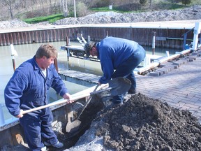 Chris Vanden Dongen, left and Bill DeBie, work on the waterline at a work party held at the Port Glasgow Yacht Club Saturday. The line needs to be replaced this year.