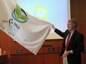 Sarnia Mayor Mike Bradley unveils the official flag for Sarnia's 100 year Centennial Celebrations at council chambers recently, during a press conference highlighting details of the events planned around the city for 2014. TARA JEFFREY/THE OBSERVER/QMI AGENCY