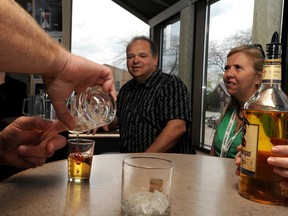 Terry Easterby, of the Community Health Services Department, measures OPP Const. Todd Monaghan's estimate of what a standard shot of liquor looks like in a cup with ice. Several community members took part in the challenge of eyeballing pours of pints and shots. Here, Dave Brown and Natalie Leduc look on as Monaghan's shot pour is measured at 2.0 oz. The Rethink Your Drinking Pour Challenge was held at the Union Station Bar and Grill Tuesday. BLAIR TATE / FOR THE OBSERVER / QMI AGENCY.